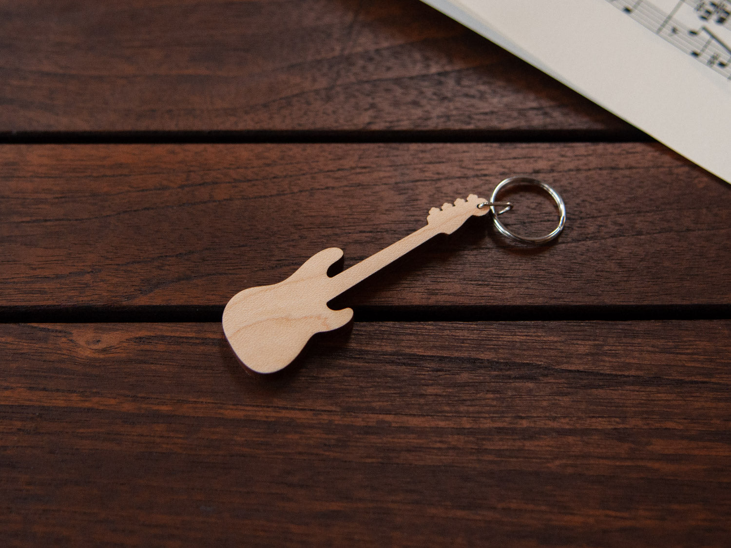 A bass guitar shaped keychain made from maple wood