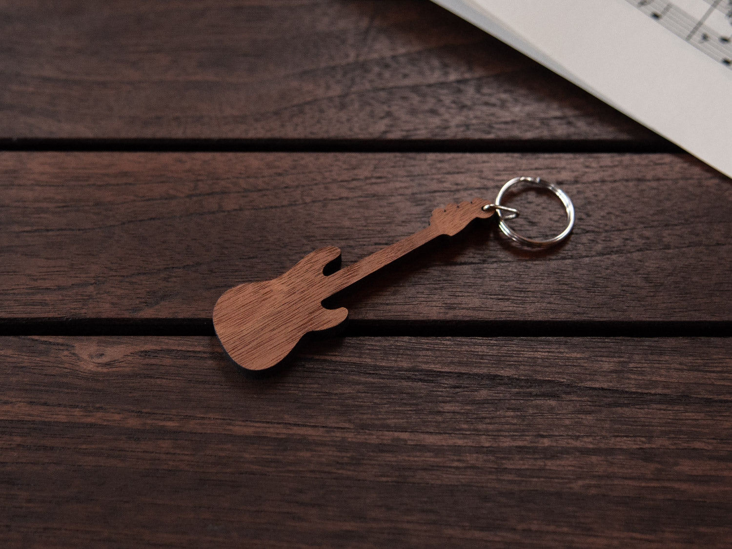 A bass guitar shaped keychain made from walnut wood