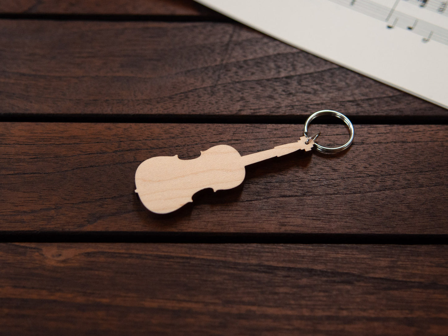 A cello shaped keychain made from maple wood