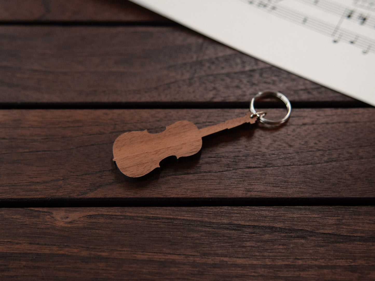 A cello shaped keychain made from walnut wood