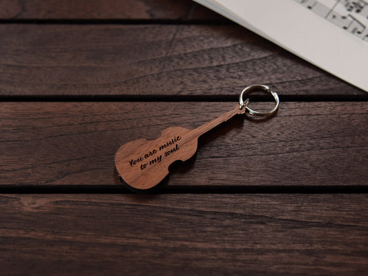 A double bass shaped keychain made from walnut wood, with personalized engraving