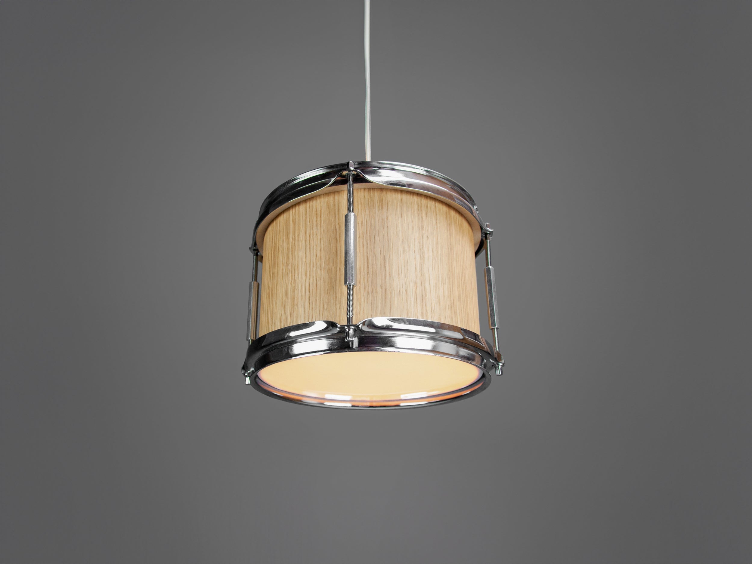 A pendant light made from a drum, with a light oak finish