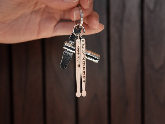 Keychain in the shape of drumsticks, made from maple wood. A drum key is also attached to the key ring.