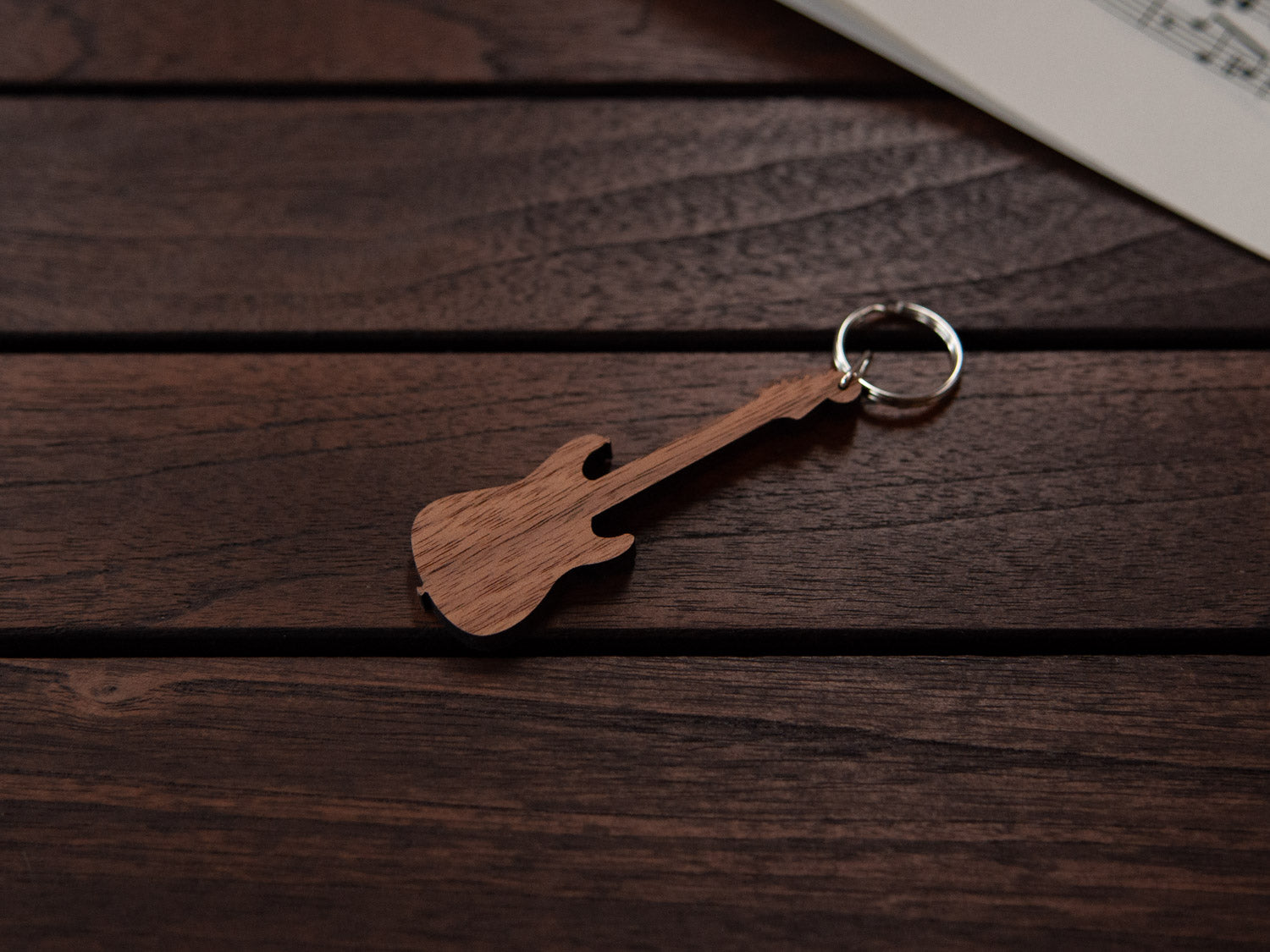 A walnut wood keychain in the shape of an electric guitar