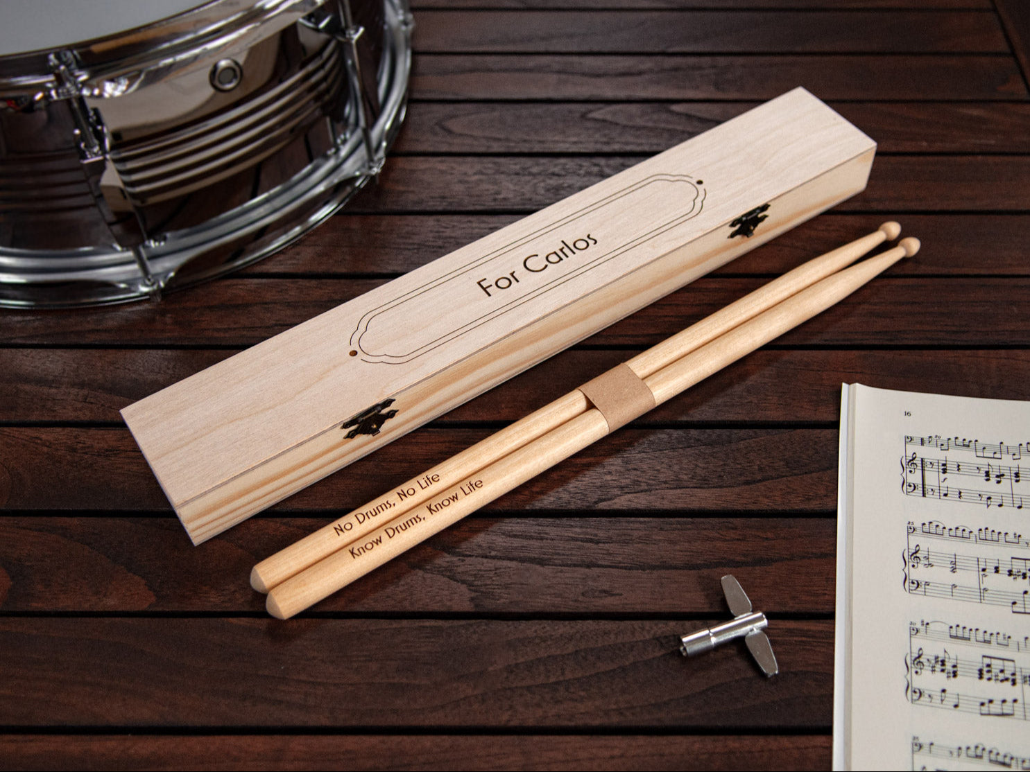 engraved drumsticks made from maple wood, in front of a tailor made engraved wooden box