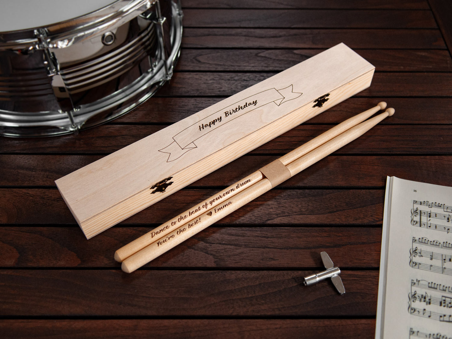 engraved drumsticks made from maple wood, in front of a tailor made engraved wooden box