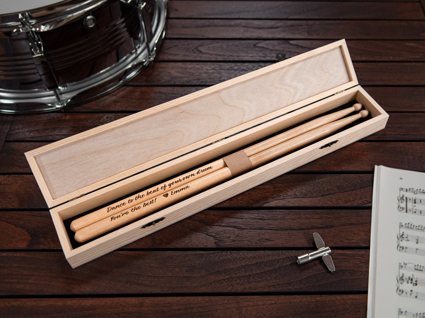 wooden drumsticks engraved with a personal message, placed in a tailor made wooden box