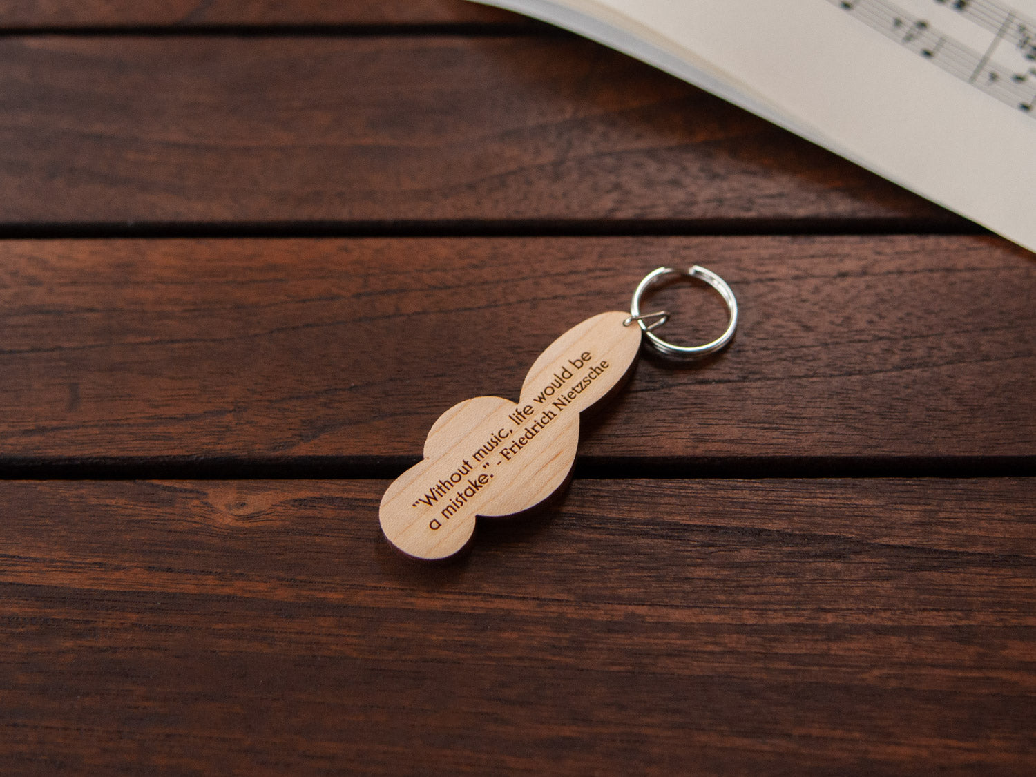 the back of a maple wood keychain in the shape of g-clef, with custom engraving