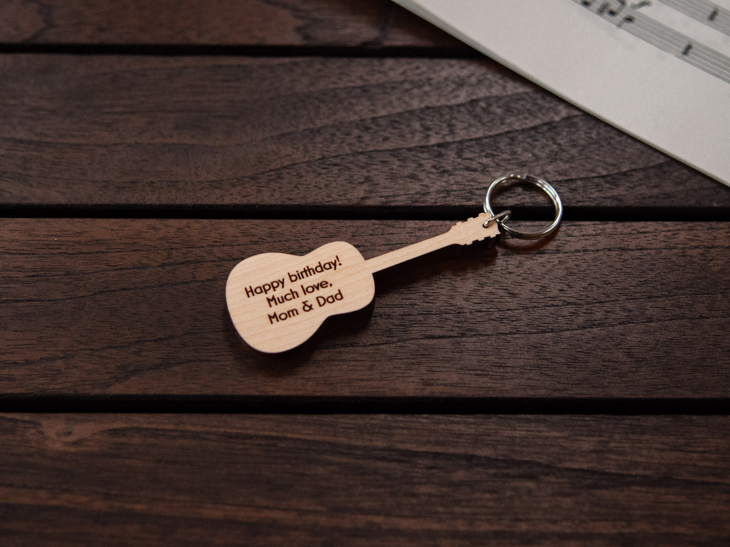 A keychain designed like a guitar, crafted from maple wood, with personalized engraving.