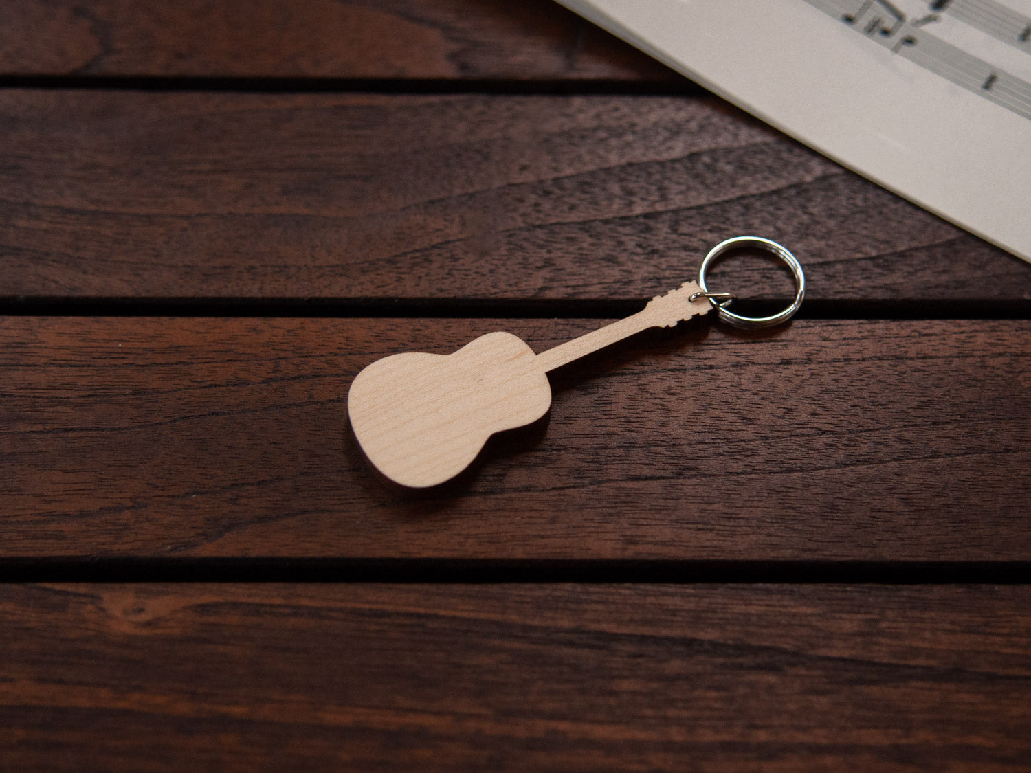 A maple wood keychain in the shape of a guitar