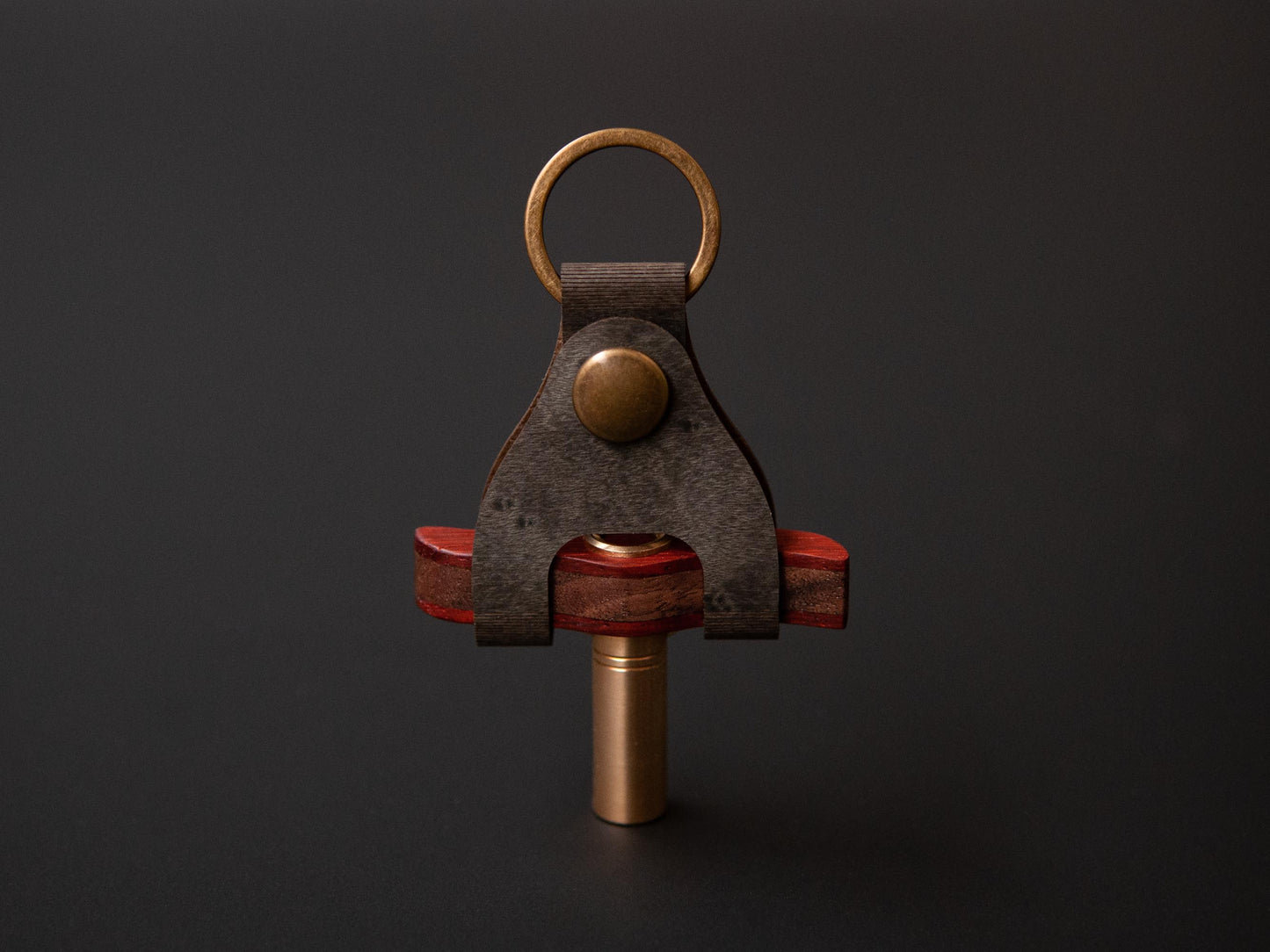 a wooden drum key place in a tailor made case, which has a dark green color with brass details