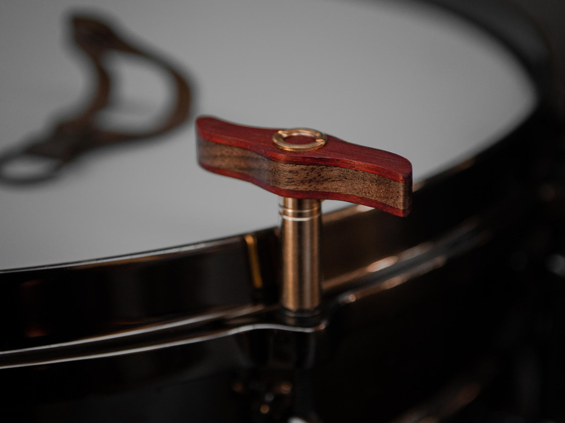 wooden drum key with brass details, mounted on a black drum