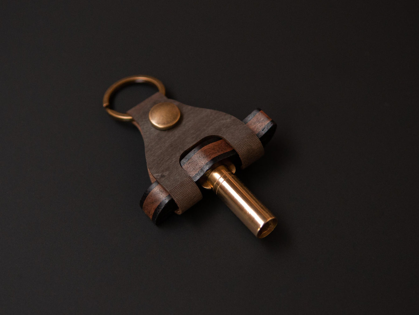 a wooden drum key place in a tailor made case, which has a dark green color with brass details