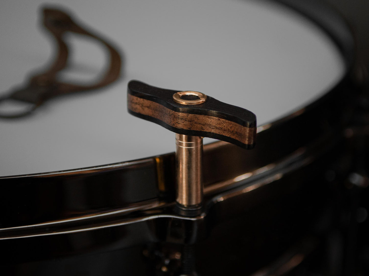 wooden drum key with brass details, mounted on a black drum