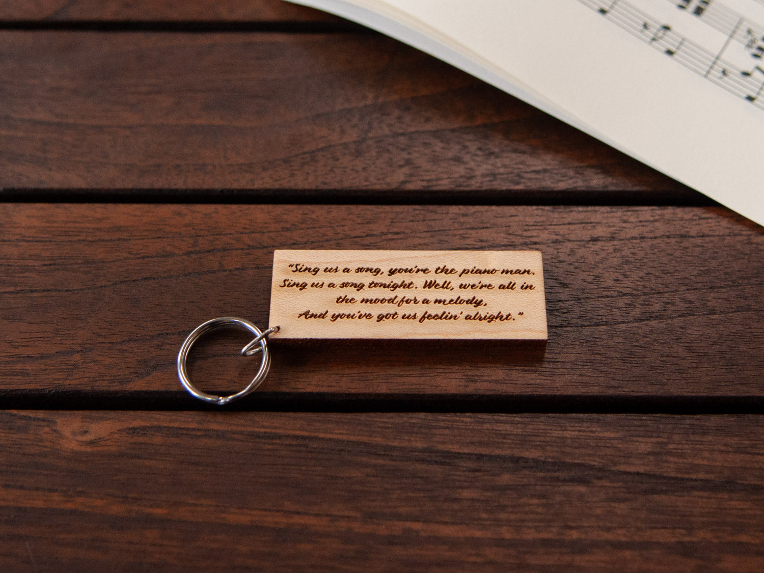 The backside of a maple piano keychain, with custom engraving