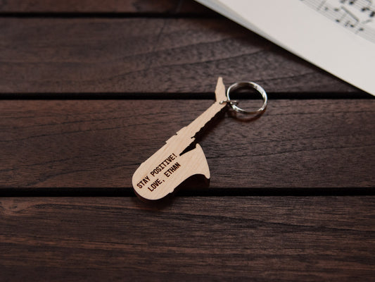 A keychain designed like a saxophone, crafted from maple wood, with personalized engraving.