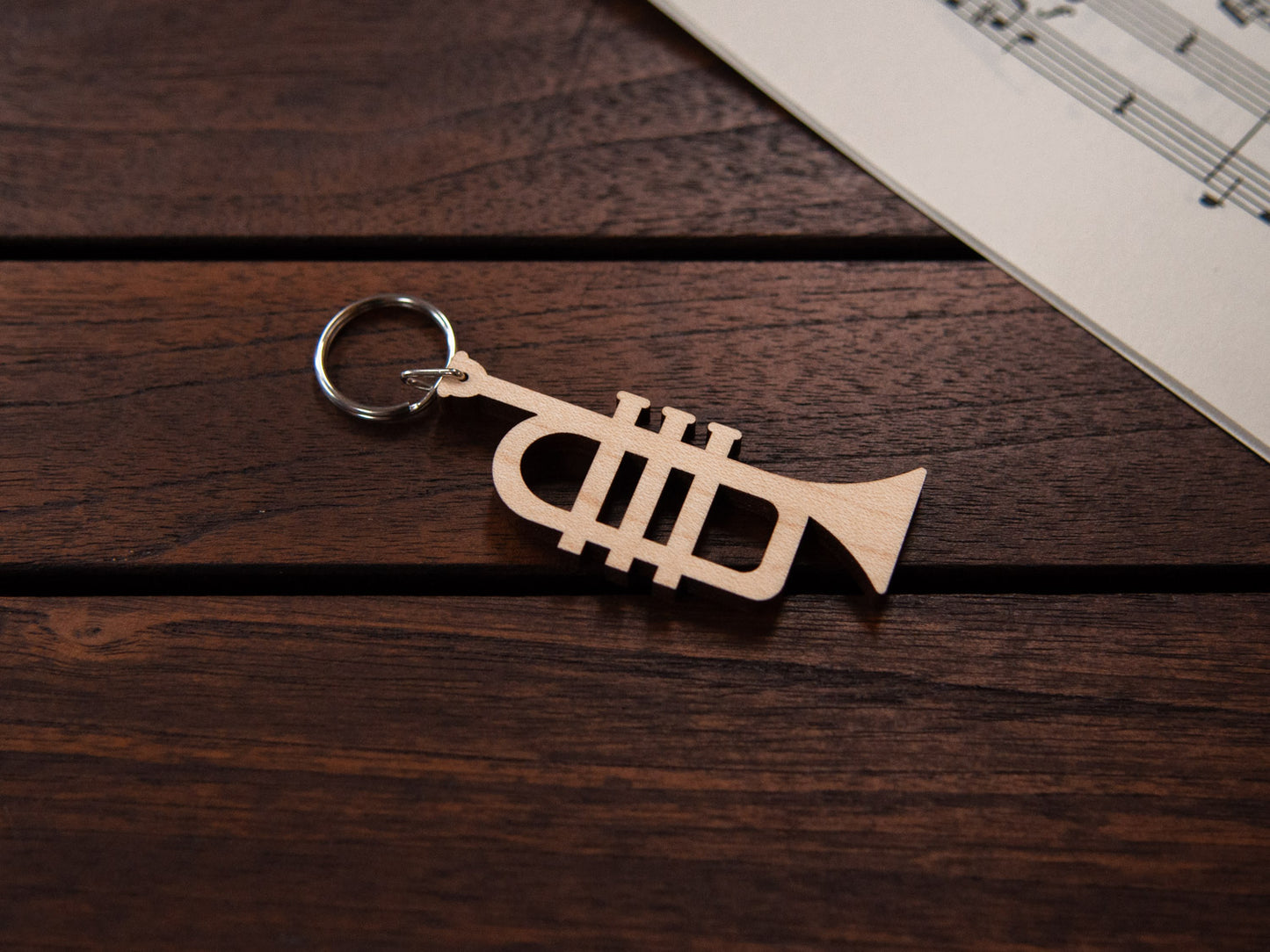 A maple wood keychain in the shape of a trumpet