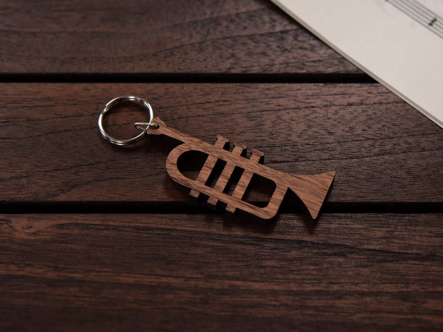 A walnut wood keychain in the shape of a trumpet