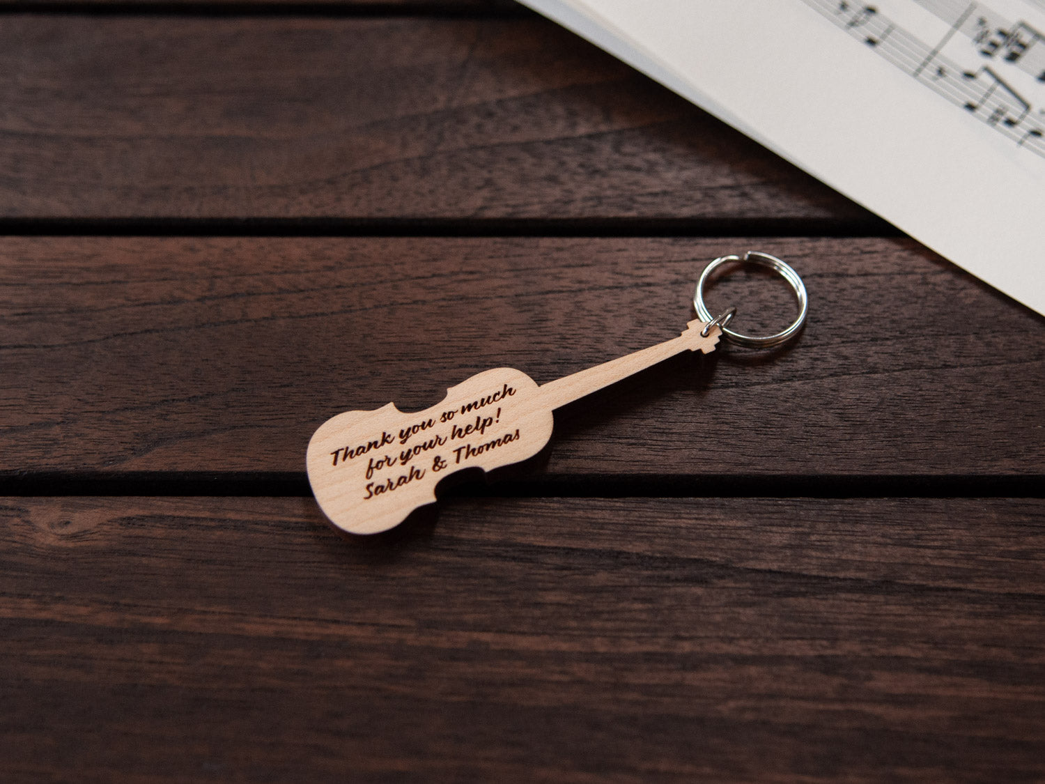 A keychain designed like a violin, crafted from maple wood, with personalized engraving.