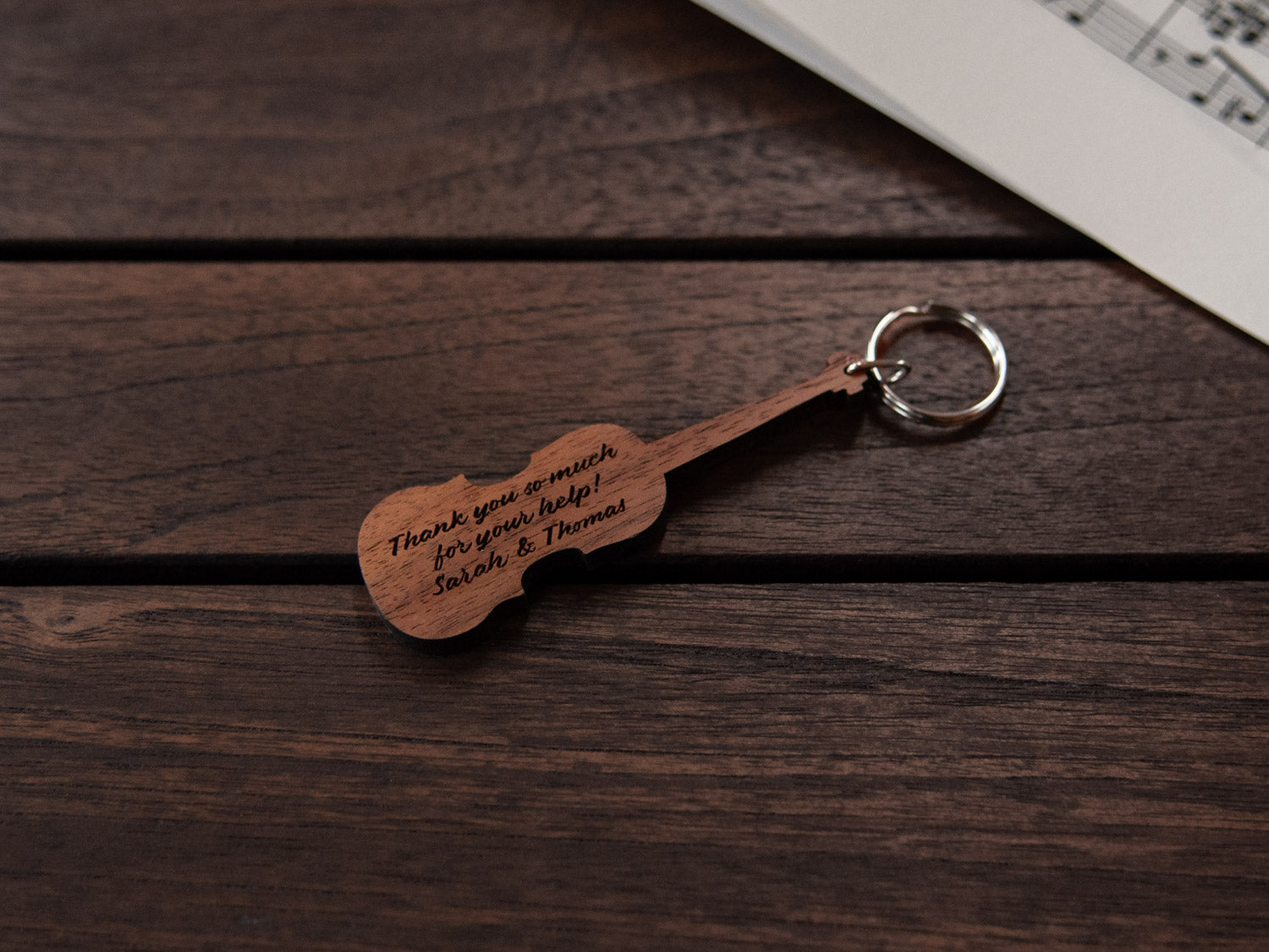 A keychain designed like a violin, crafted from walnut wood, with personalized engraving.