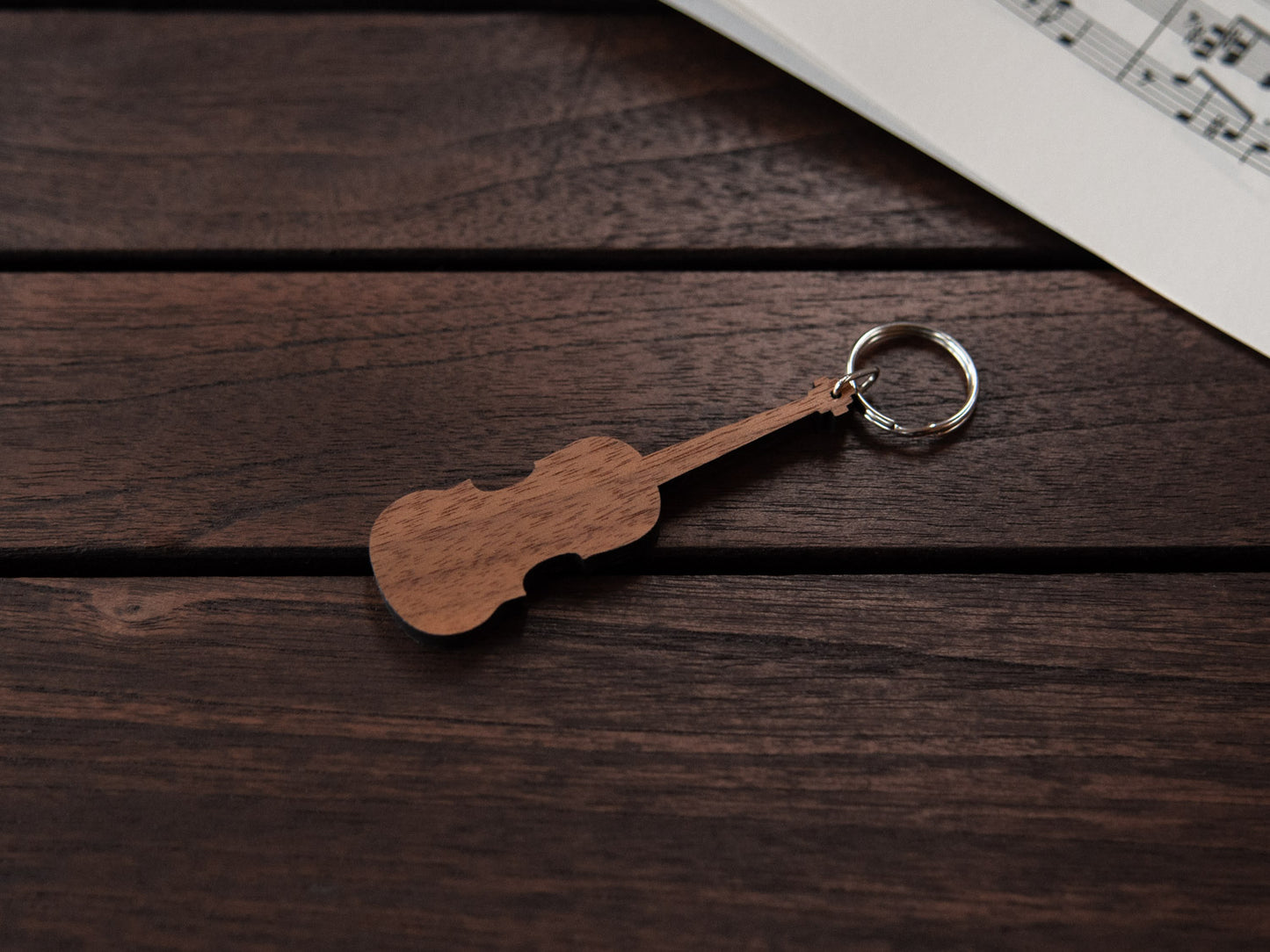 A walnut wood keychain in the shape of a violin